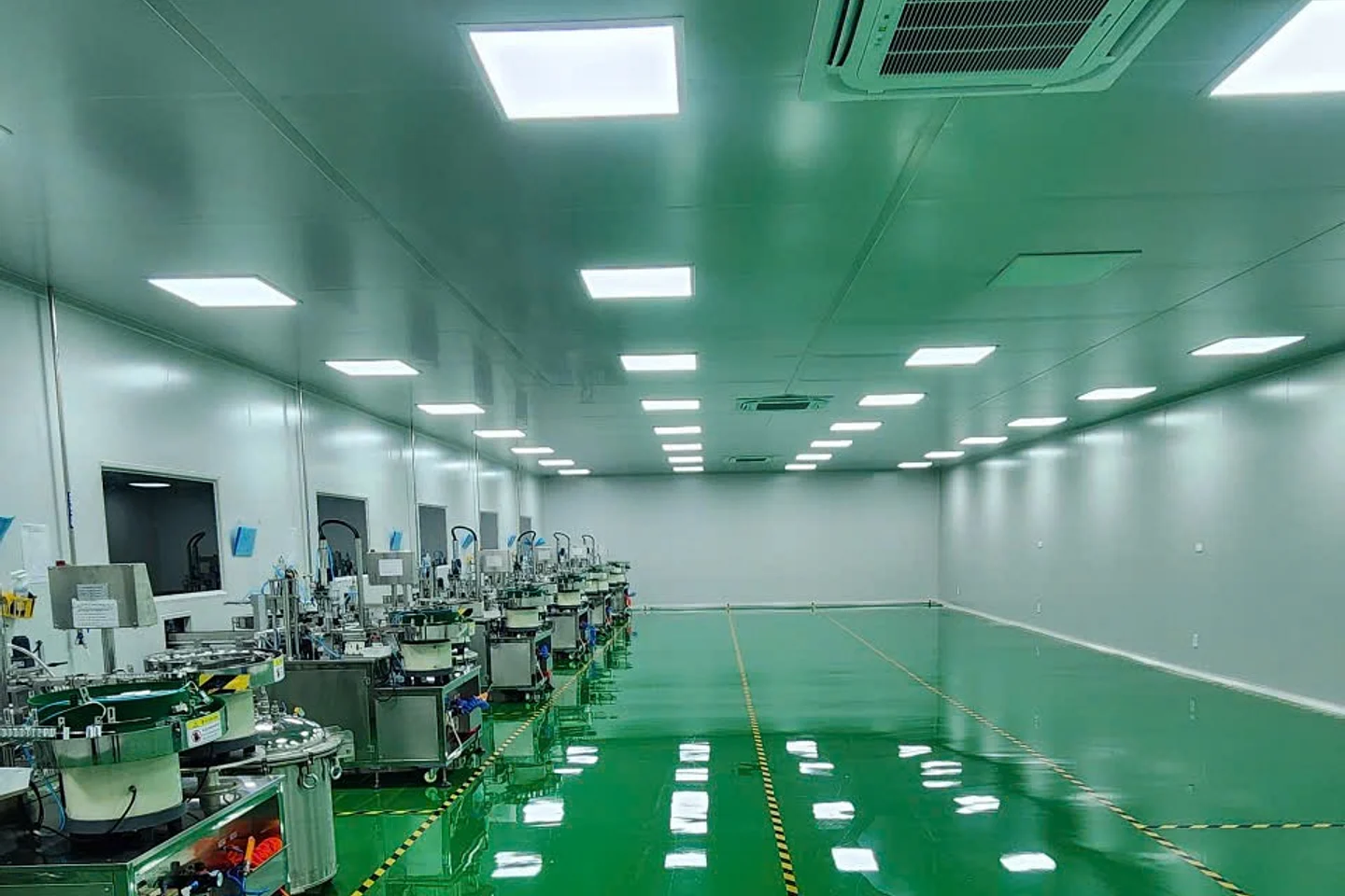 Khu vực phòng sạch thực tế với máy móc sản xuất và sàn epoxy xanh